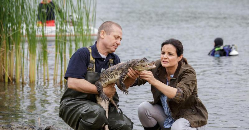 Susanne und ein Helfer haben einen Kaiman im See gefangen.